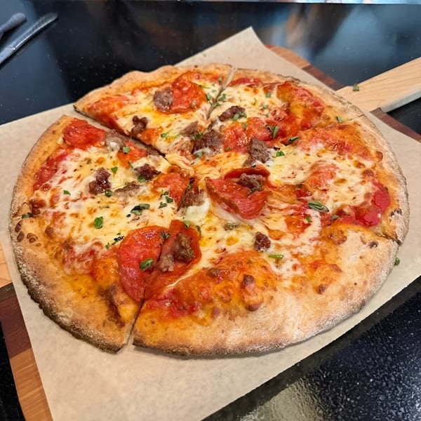 Ovest Via's Italian pizza, topped with pepperoni, sausage, melted cheese, and fresh herbs.